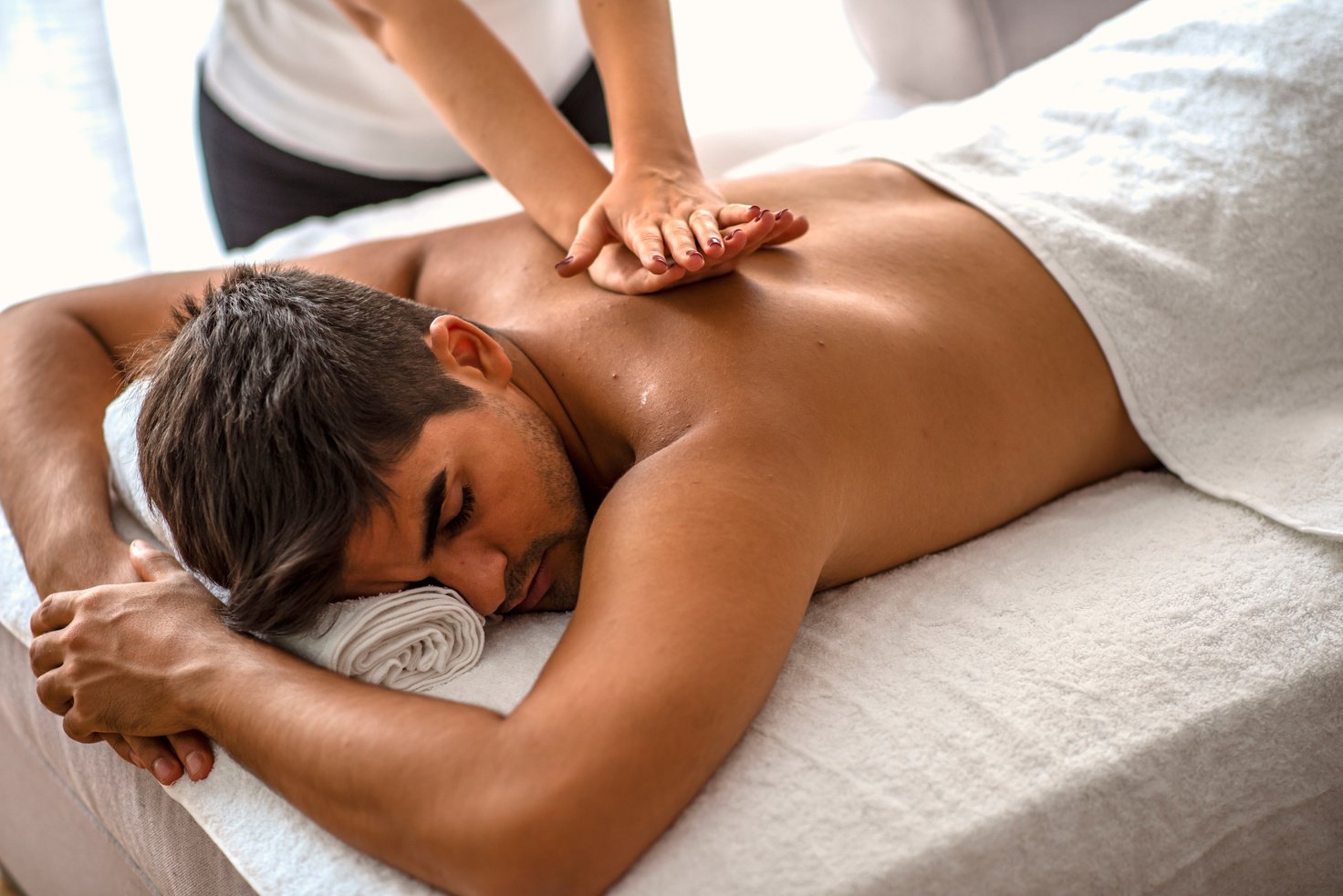 Man relaxing on massage table receiving massage.